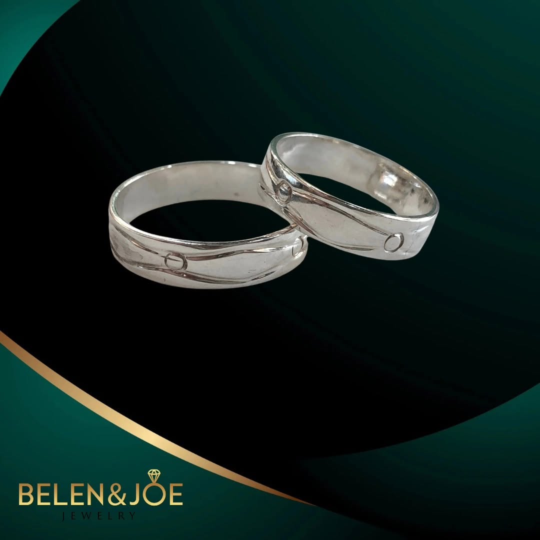 White gold wedding bands on emerald backdrop